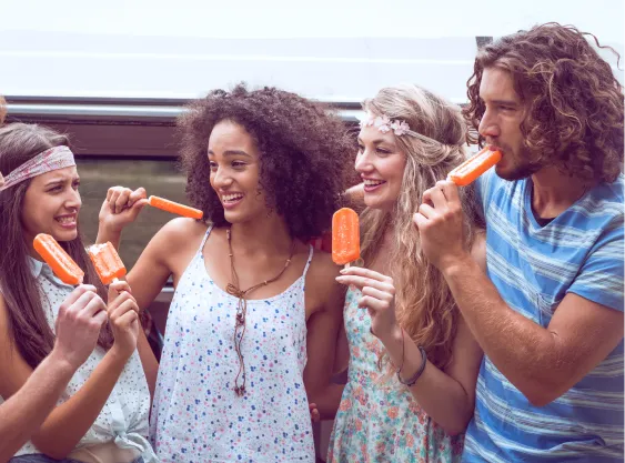 Fünf junge Erwachsene in sommerlicher Kleidung genießen orangefarbene Eis am Stiel vor einem Van. Sie lachen, reden und wirken eng verbunden – ein Bild voller Lebensfreude, Sommerleichtigkeit und Freundschaft.
